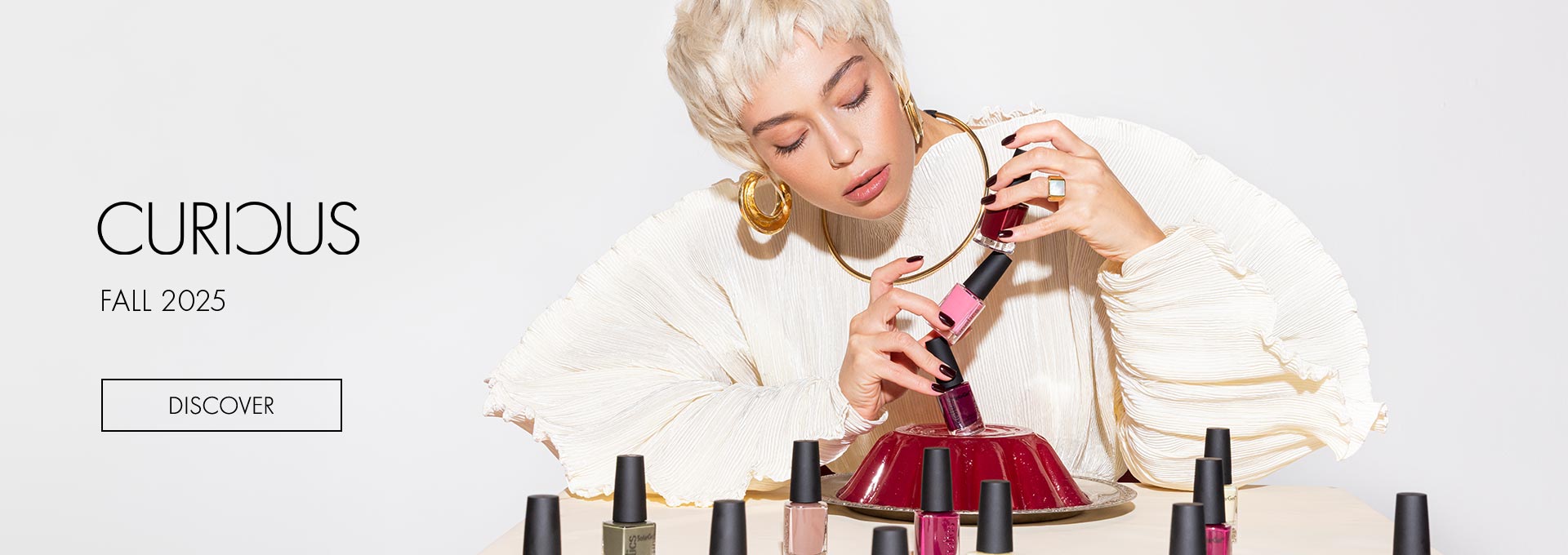 Woman applying nail polish with a 'Curious' Fall 2025 theme